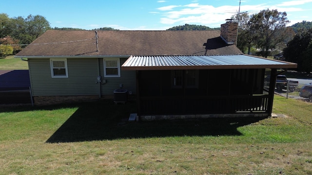 view of home's exterior with central air condition unit, a sunroom, and a yard