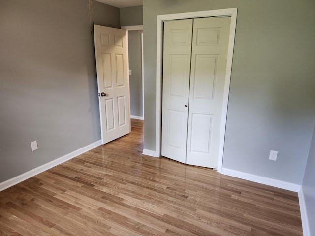 unfurnished bedroom featuring a closet and light wood-type flooring