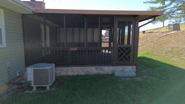 property entrance with central air condition unit and a yard