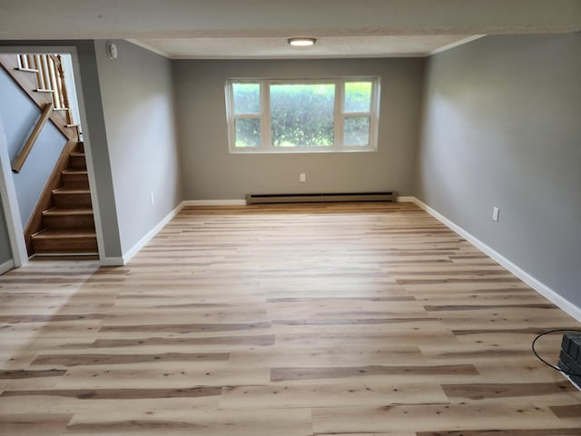 spare room featuring light hardwood / wood-style flooring, crown molding, and a baseboard radiator