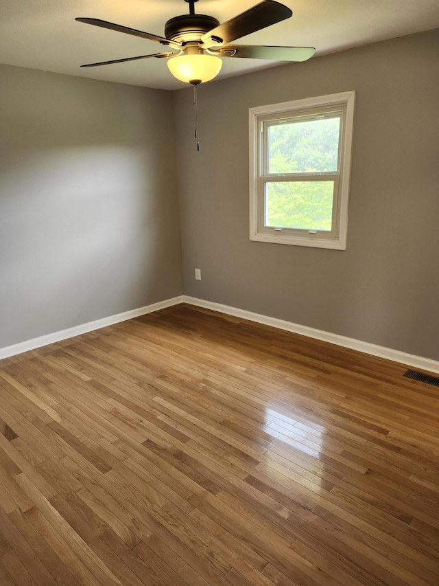 spare room with hardwood / wood-style floors and ceiling fan