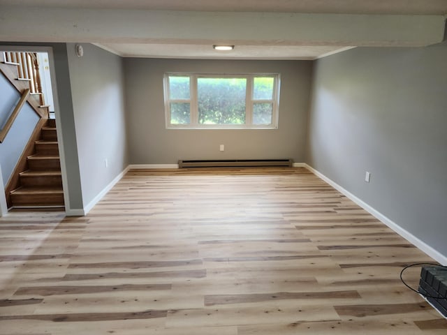 spare room with ornamental molding, light hardwood / wood-style floors, and a baseboard heating unit