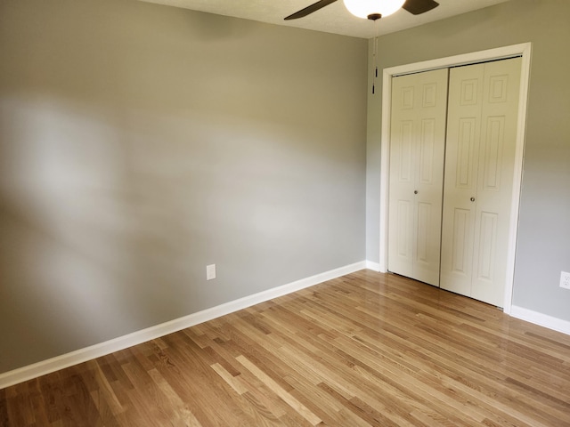 unfurnished bedroom featuring ceiling fan, a closet, and light hardwood / wood-style flooring