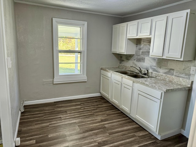 kitchen with a textured ceiling, white cabinetry, sink, and tasteful backsplash