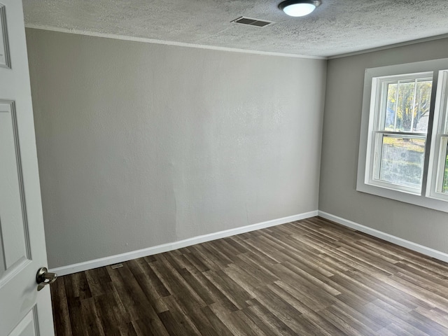 empty room with wood-type flooring, a textured ceiling, and ornamental molding