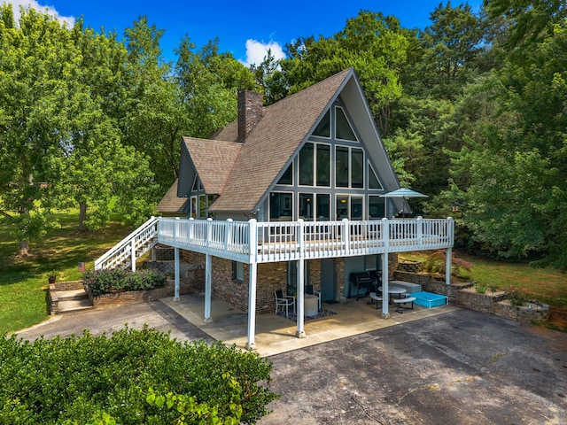 1116 Patterson St, Dandridge, TN 37725 - back of property with a patio area, a wooden deck, stone siding, a shingled roof, and a chimney