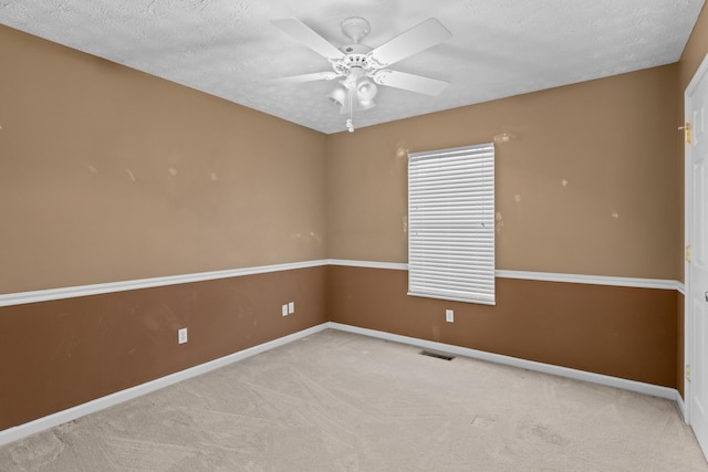 carpeted empty room with ceiling fan and a textured ceiling