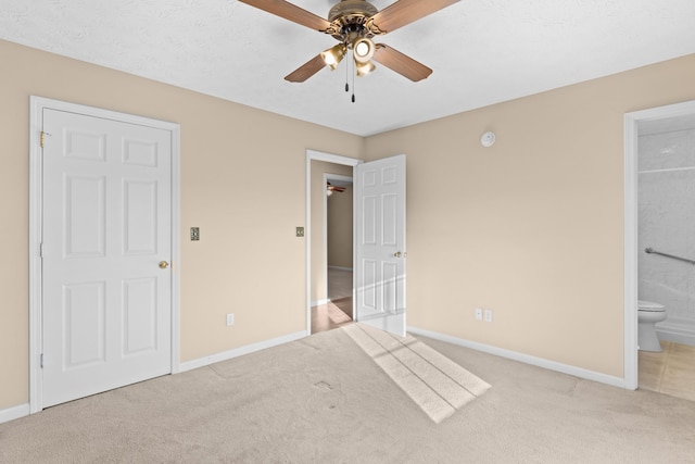 unfurnished bedroom with ensuite bathroom, light colored carpet, a textured ceiling, and ceiling fan