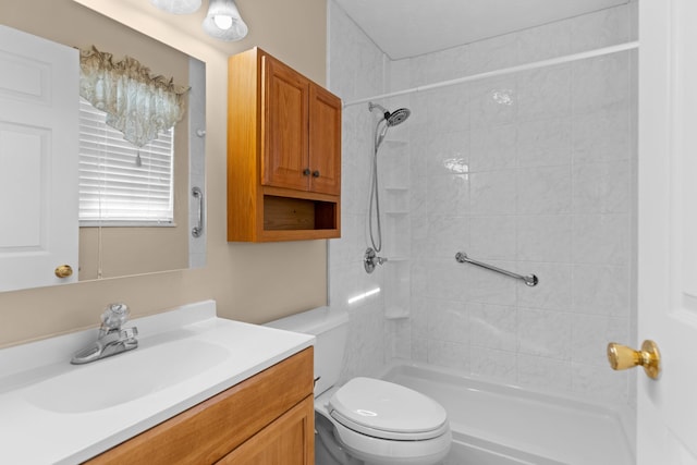 bathroom featuring tiled shower, vanity, and toilet