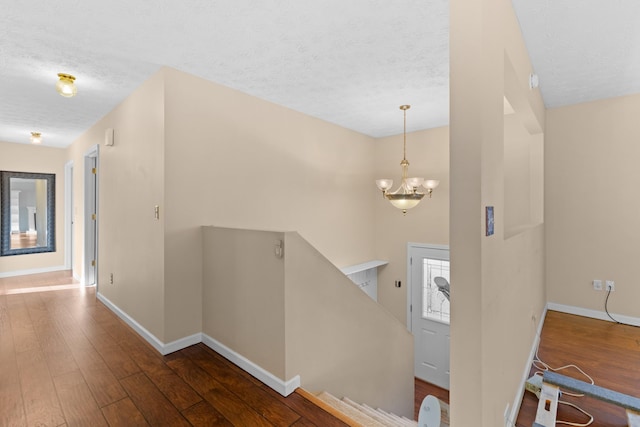 entryway featuring dark hardwood / wood-style flooring, a notable chandelier, and a textured ceiling