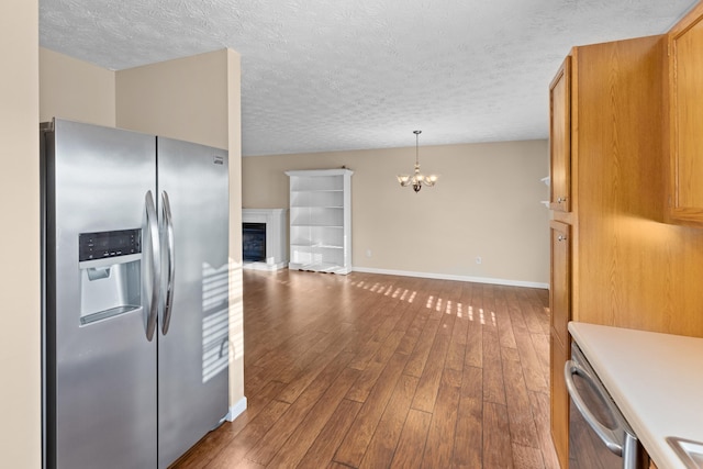 kitchen featuring pendant lighting, dark hardwood / wood-style floors, a textured ceiling, stainless steel fridge with ice dispenser, and a chandelier