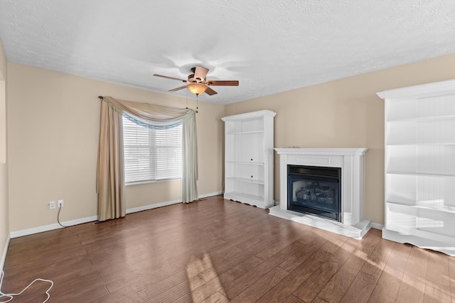 unfurnished living room with ceiling fan, dark hardwood / wood-style floors, and a textured ceiling