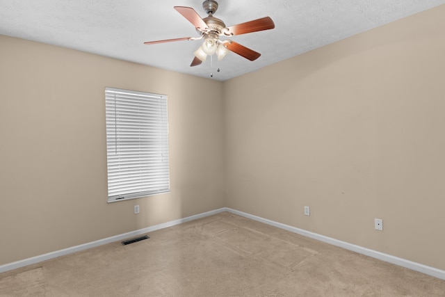 carpeted empty room featuring a textured ceiling and ceiling fan