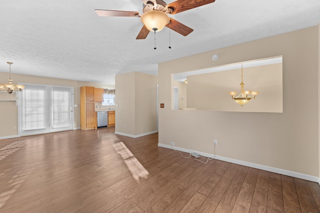 unfurnished living room featuring dark hardwood / wood-style floors, ceiling fan with notable chandelier, and a textured ceiling