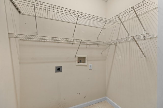 washroom featuring light tile patterned flooring, hookup for an electric dryer, and hookup for a washing machine