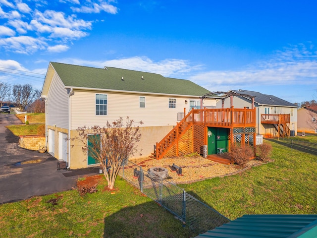 back of property with a garage, a yard, and a deck