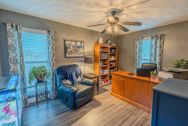 home office featuring ceiling fan, a textured ceiling, and light wood-type flooring