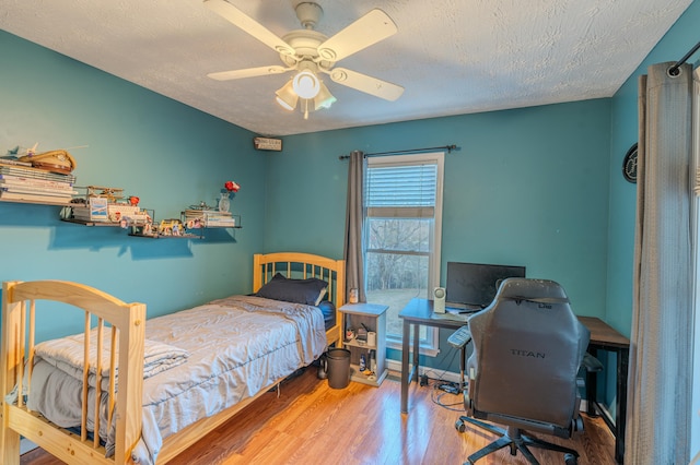 bedroom featuring a textured ceiling, wood-type flooring, and ceiling fan