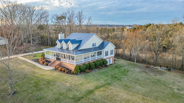 back of property with a yard and covered porch