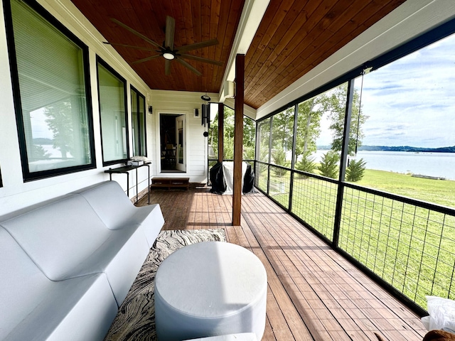 sunroom / solarium featuring a water view and a ceiling fan