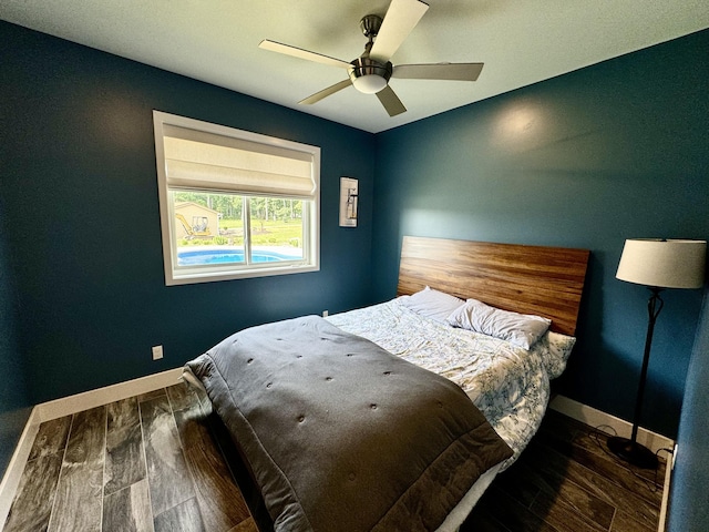 bedroom featuring wood finished floors, baseboards, and ceiling fan