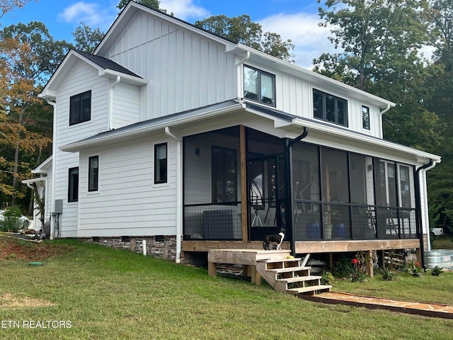 view of front of house featuring a front yard, a sunroom, and board and batten siding