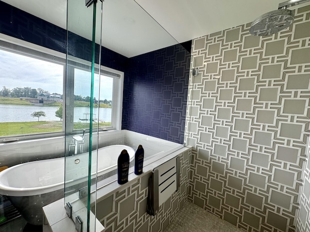 bathroom with a soaking tub and a water view