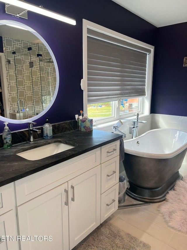 bathroom with vanity, a freestanding bath, tiled shower, and tile patterned floors