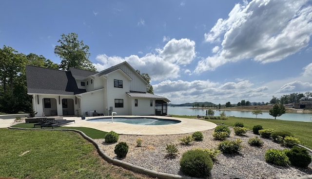 outdoor pool featuring a water view, a lawn, and a patio