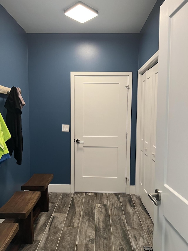 mudroom featuring dark wood-style floors and baseboards