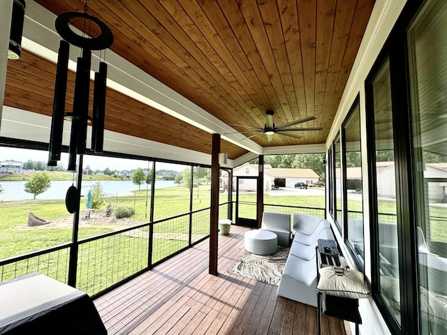 sunroom with a water view, a ceiling fan, and vaulted ceiling