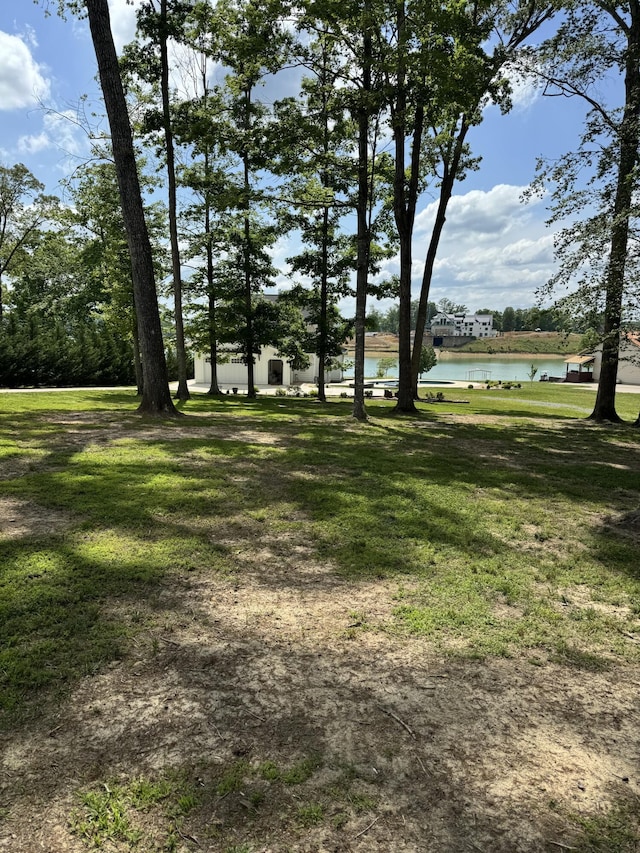 view of green lawn with a water view