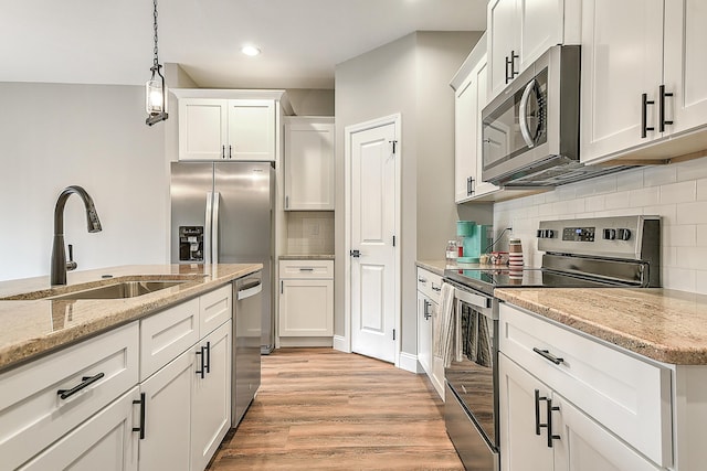 518 Deborahs Way, Greeneville, TN 37743 - kitchen with stainless steel appliances, a sink, light wood-style floors, white cabinets, and backsplash