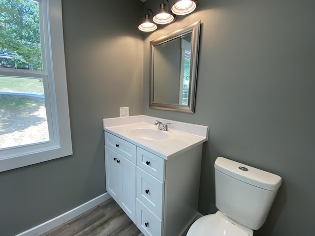 bathroom featuring wood-type flooring, vanity, and toilet