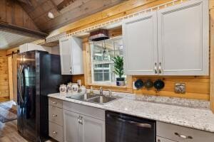 kitchen with wooden walls, dishwashing machine, freestanding refrigerator, vaulted ceiling, and a sink