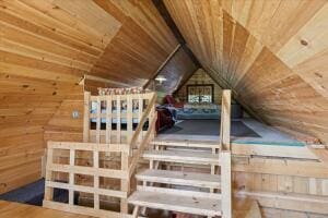 interior space featuring vaulted ceiling, wood ceiling, and wooden walls