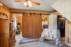 living area with ceiling fan and wood finished floors