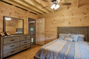 bedroom featuring light wood-type flooring, beam ceiling, and wood walls