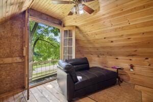 sitting room featuring lofted ceiling, wood walls, wooden ceiling, and a wealth of natural light