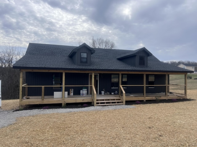 view of front facade with a porch, roof with shingles, and board and batten siding