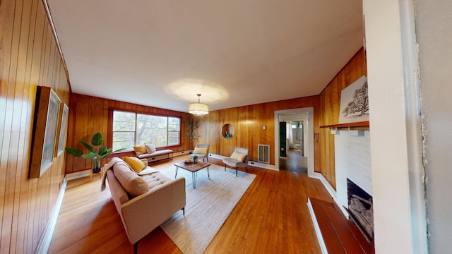 living room featuring light hardwood / wood-style floors and wooden walls