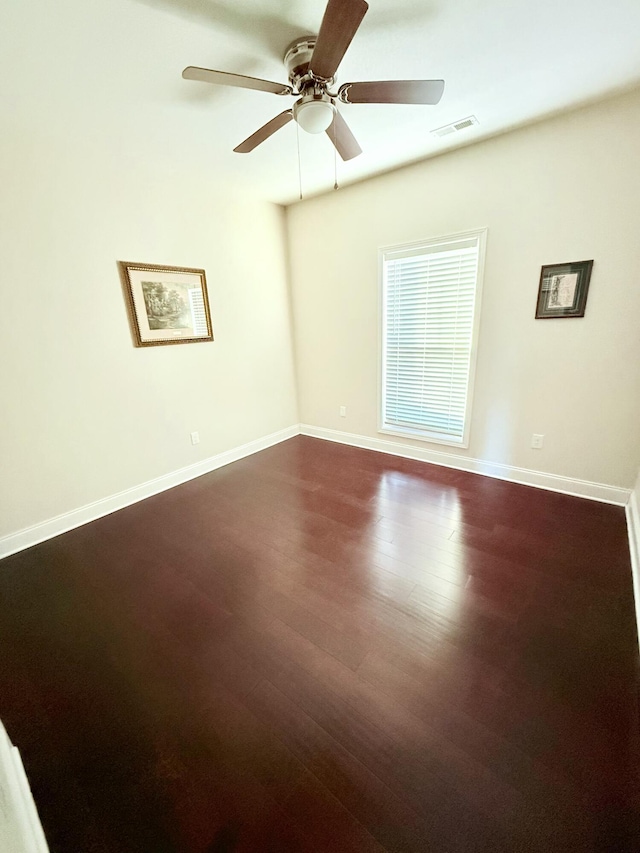 spare room with dark hardwood / wood-style flooring and ceiling fan