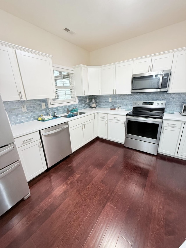 kitchen with white cabinetry, stainless steel appliances, dark hardwood / wood-style floors, and sink