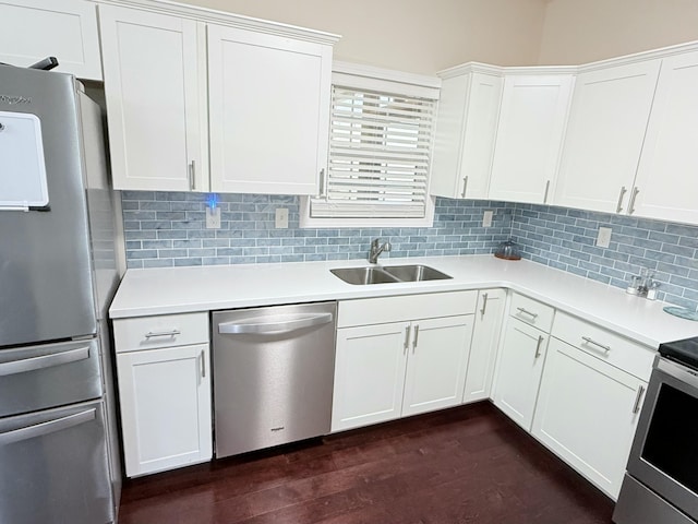 kitchen with stainless steel appliances, white cabinetry, sink, and backsplash