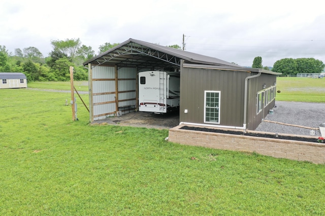 view of pole building with a carport and a lawn