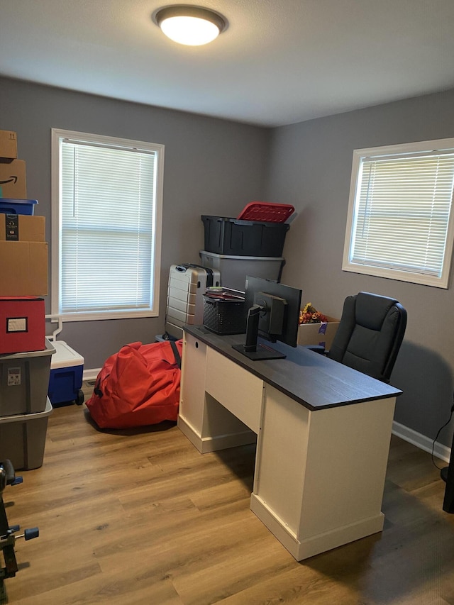 office area with light wood-style flooring and baseboards