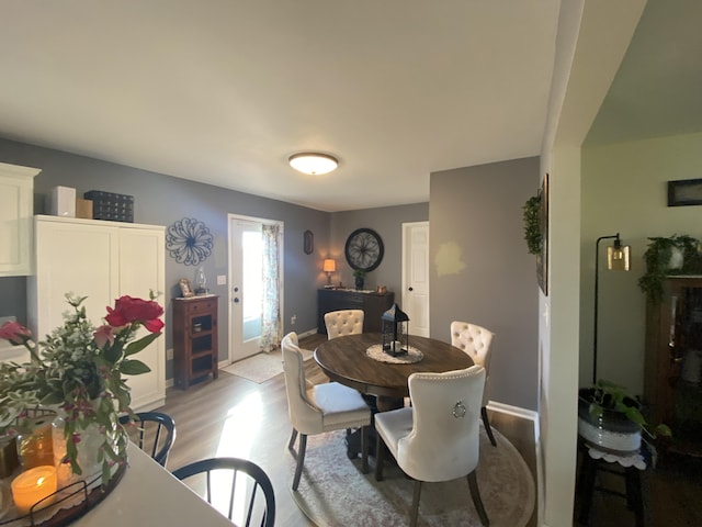 dining area with baseboards and light wood-style floors