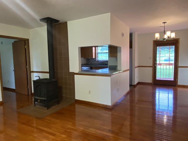 kitchen featuring backsplash, a wood stove, hanging light fixtures, and a chandelier