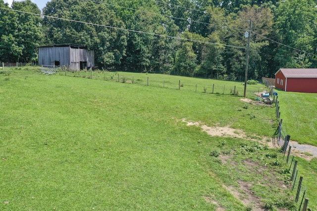 view of yard with a rural view and an outbuilding