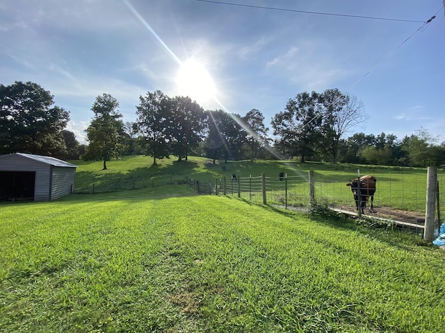 view of yard with a rural view and an outdoor structure